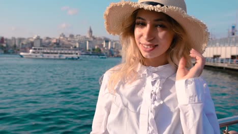 Slow-Motion:Beautiful-girl-stands-near-bosphorus-with-view-of-Galata-in-Istanbul,Turkey