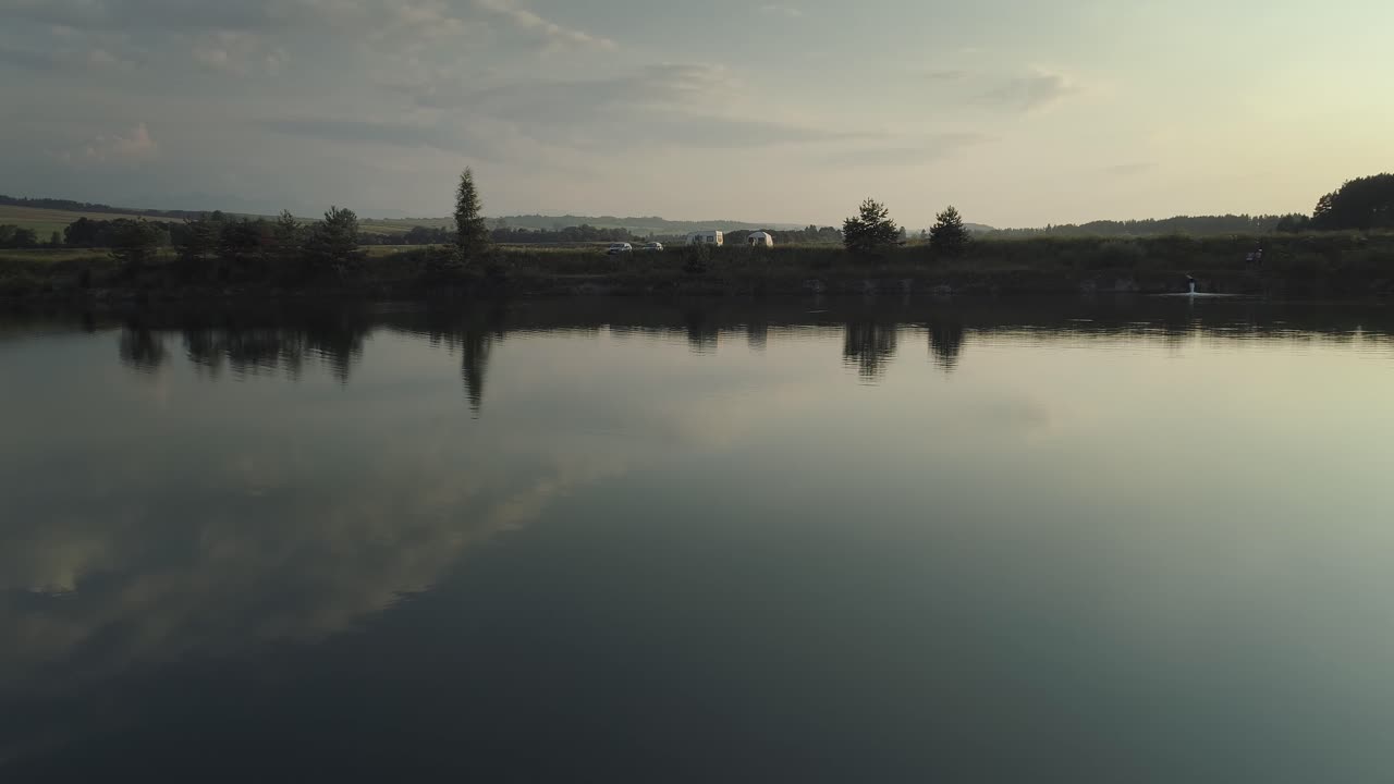 полет беспилотника на малой высоте над небольшим озером в польше