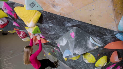 chica adolescente haciendo bouldering en el interior
