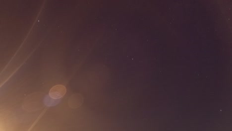 rising moon light ray n star with bokeh lens flare on dark night sky timelapse
