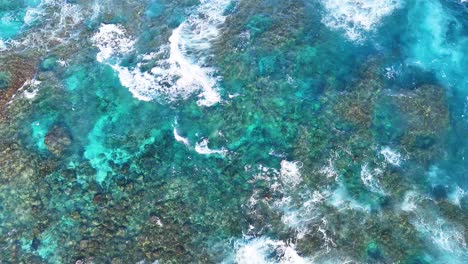 aerial view of ocean waves hitting coral reef