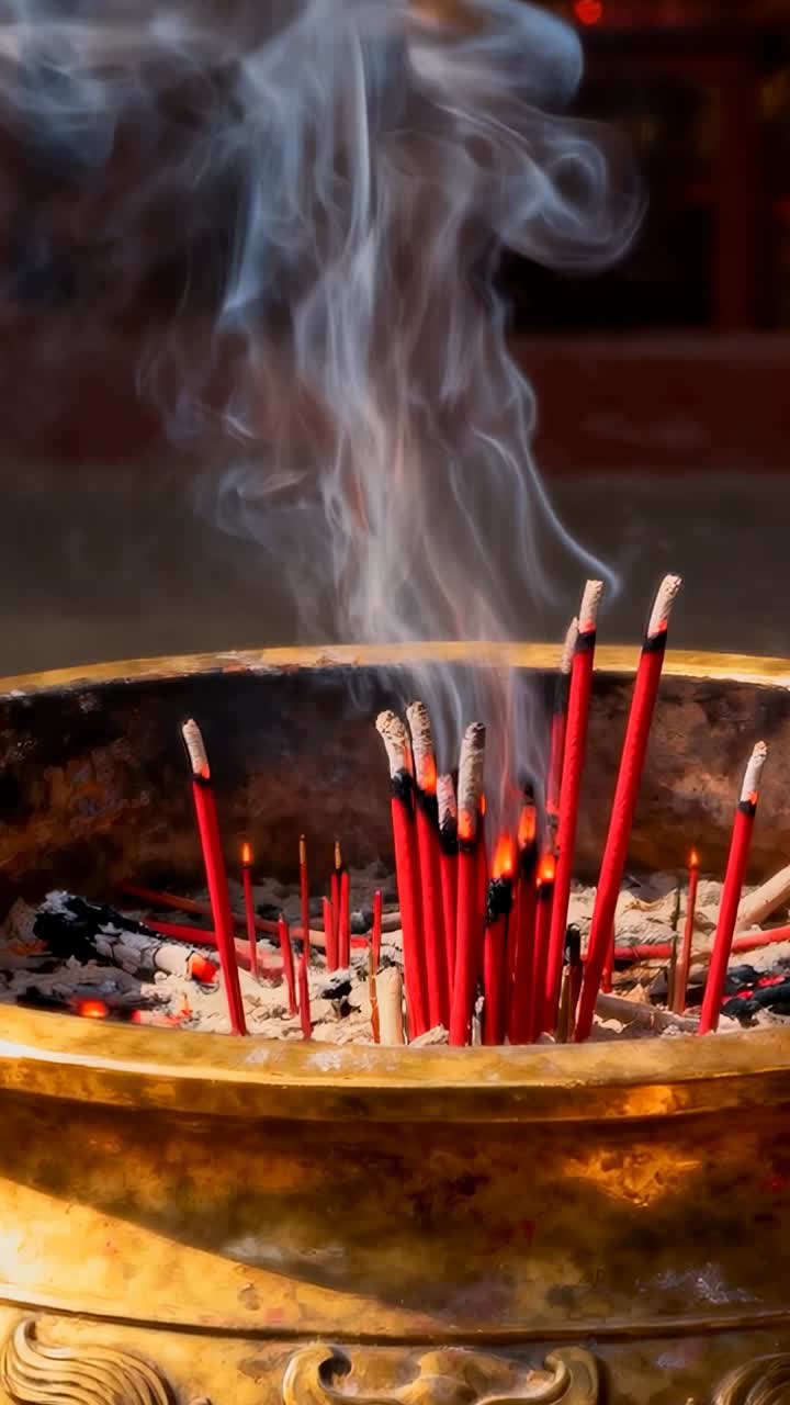Video verticale: scintille che accendono braci creando incenso rosso in un incensiere, con fumo che si arriccia per la preghiera