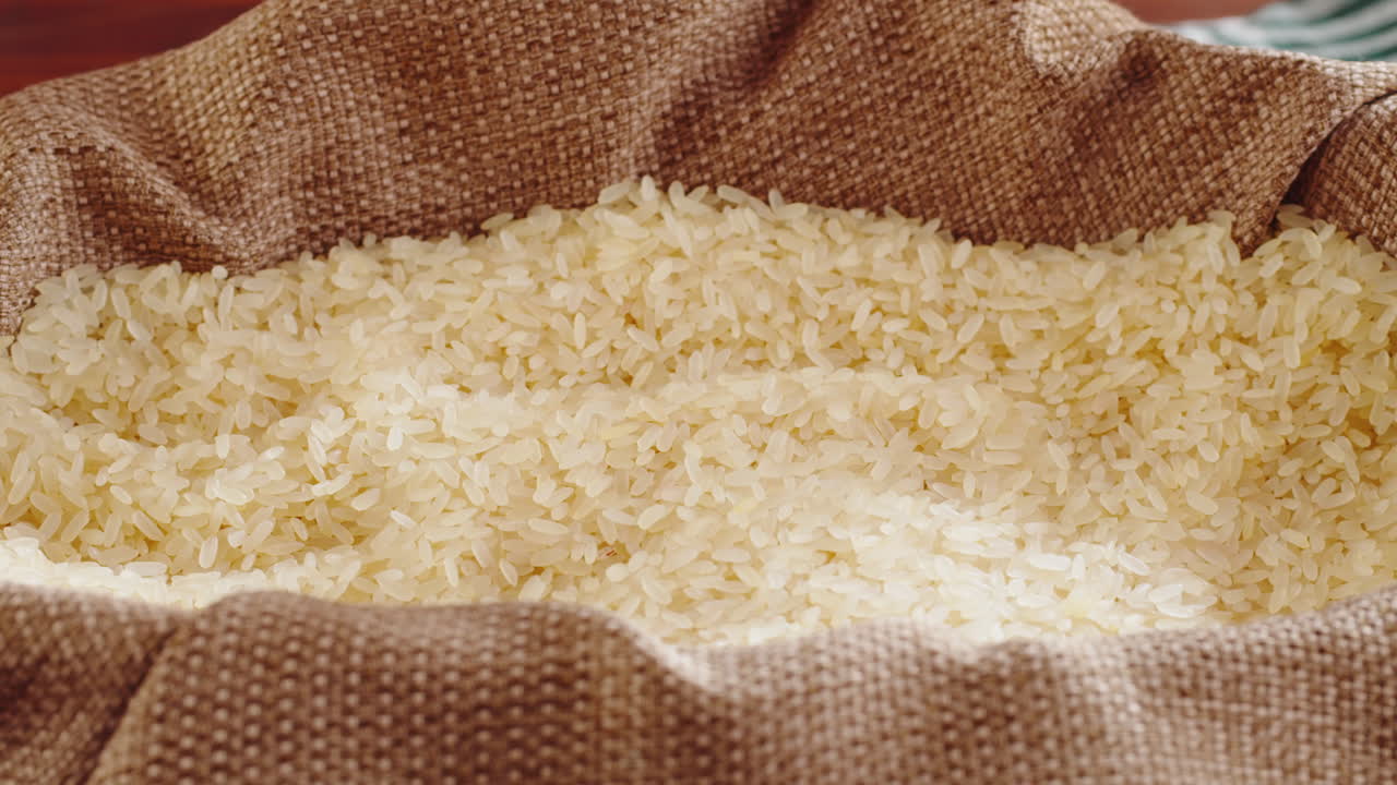 Rice being poured into a burlap sack