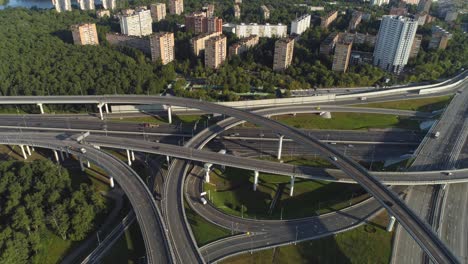 multi-level road interchange and cars traffic. drone is flying back. aerial view.