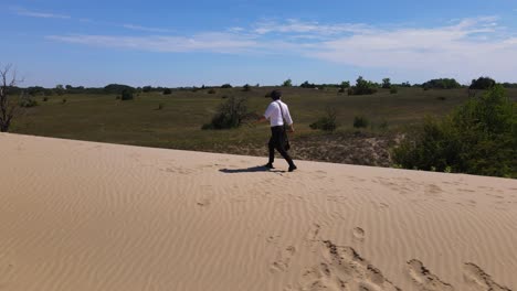 actor que interpreta al poeta sandor petofi camina por una duna de arena con vistas a fulophaza, hungría