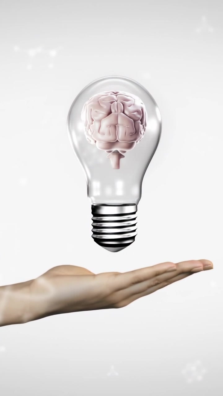 Mano destra nuda che afferra una lampadina trasparente in caduta e sostiene un cervello rotante per un concetto tecnologico.