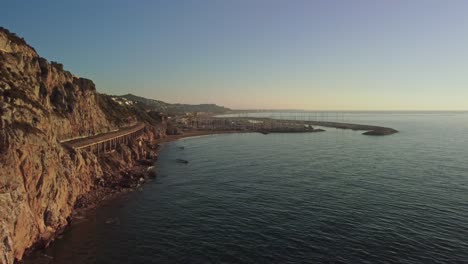 The-coastline-and-port-ginesta-at-sunrise-in-barcelona,-spain,-aerial-view