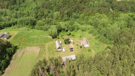 Kleines-Gehöft,-Umgeben-Von-Dichtem-Wald-In-Litauen,-Luftbahn-Timelpase-Ansicht