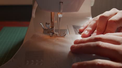 pushing fabric through a sewing machine at close proximity