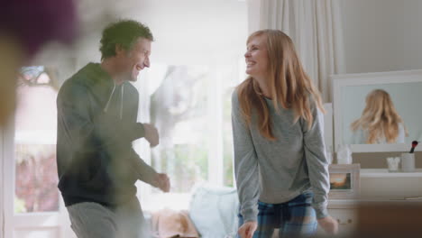 pareja joven feliz bailando en casa celebrando divirtiéndose fin de semana por la mañana juntos disfrutando de un divertido baile en el dormitorio celebración de una relación exitosa 4k footage