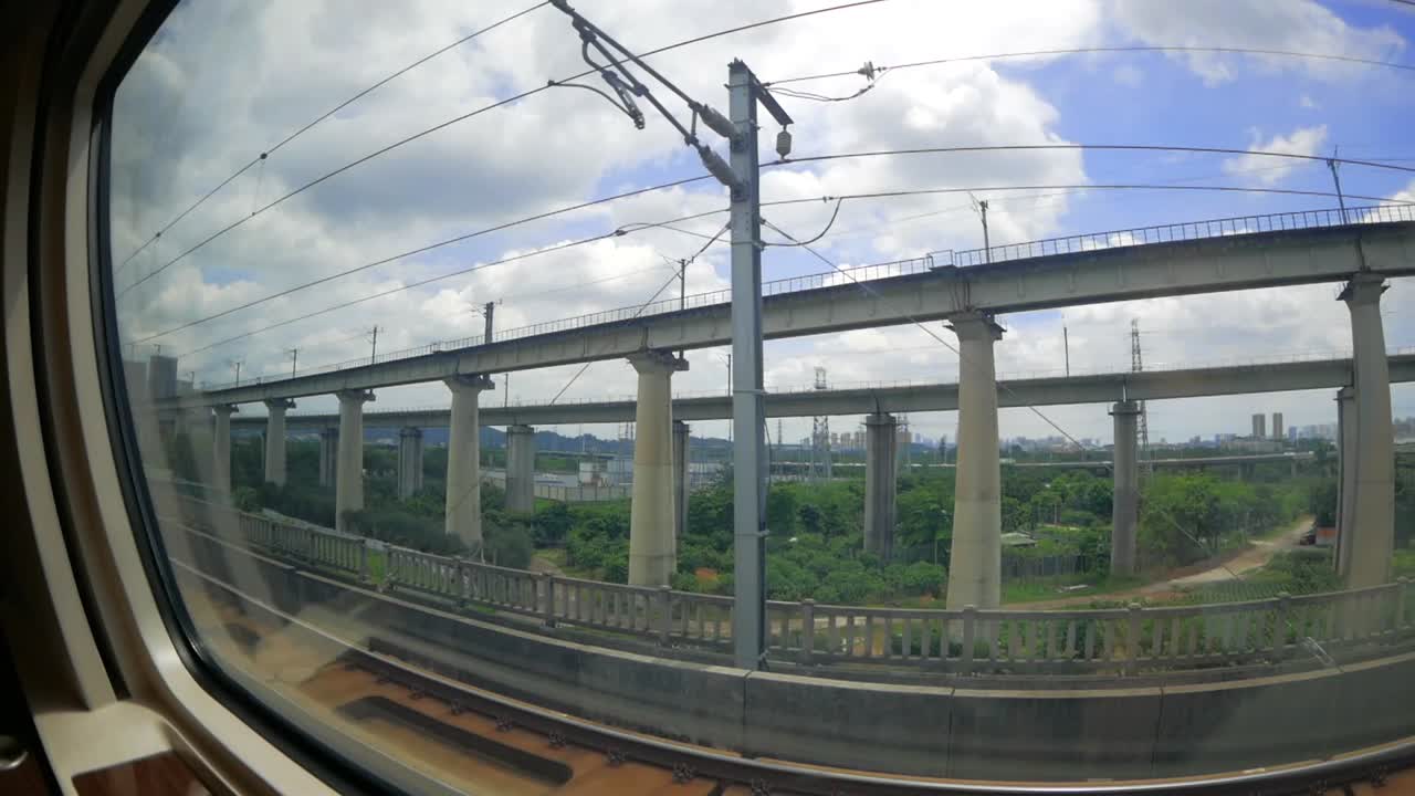 Sitting in the China high speed train and looking out of the window (POV). We can see vehicle overpasses and trees