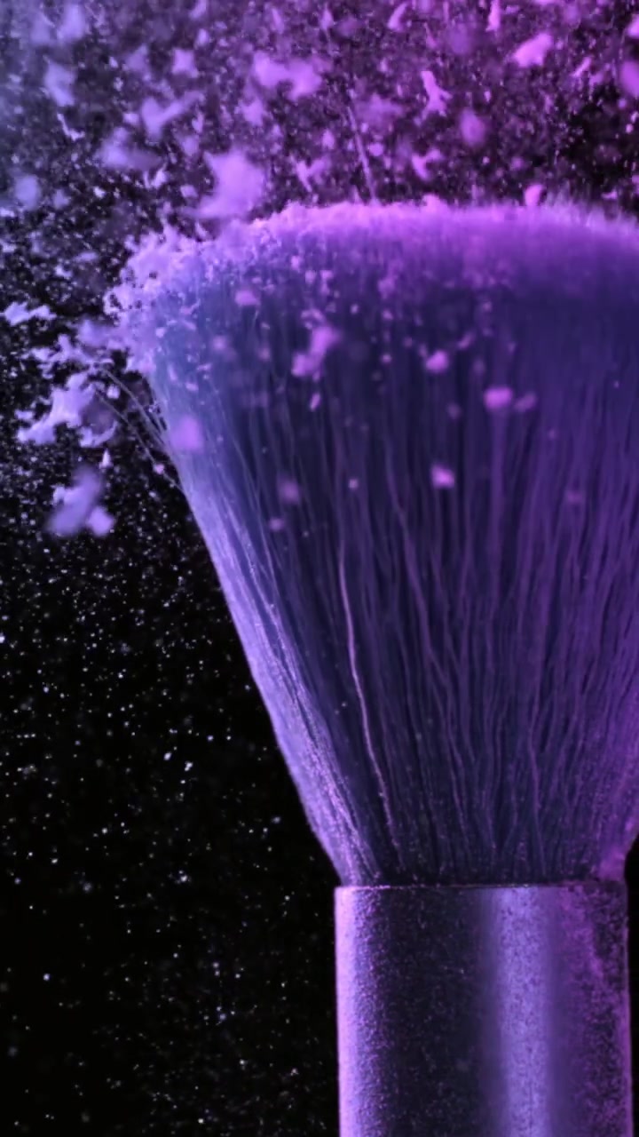 Vibrant Purple Powder Dispersing from Makeup Brush in Slow Motion