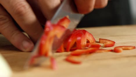 chef chopping red bell peppers