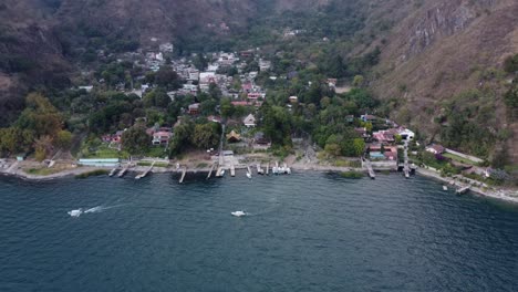 aerial: tiny village of jaibalito on mountainous shore of lake atitlan