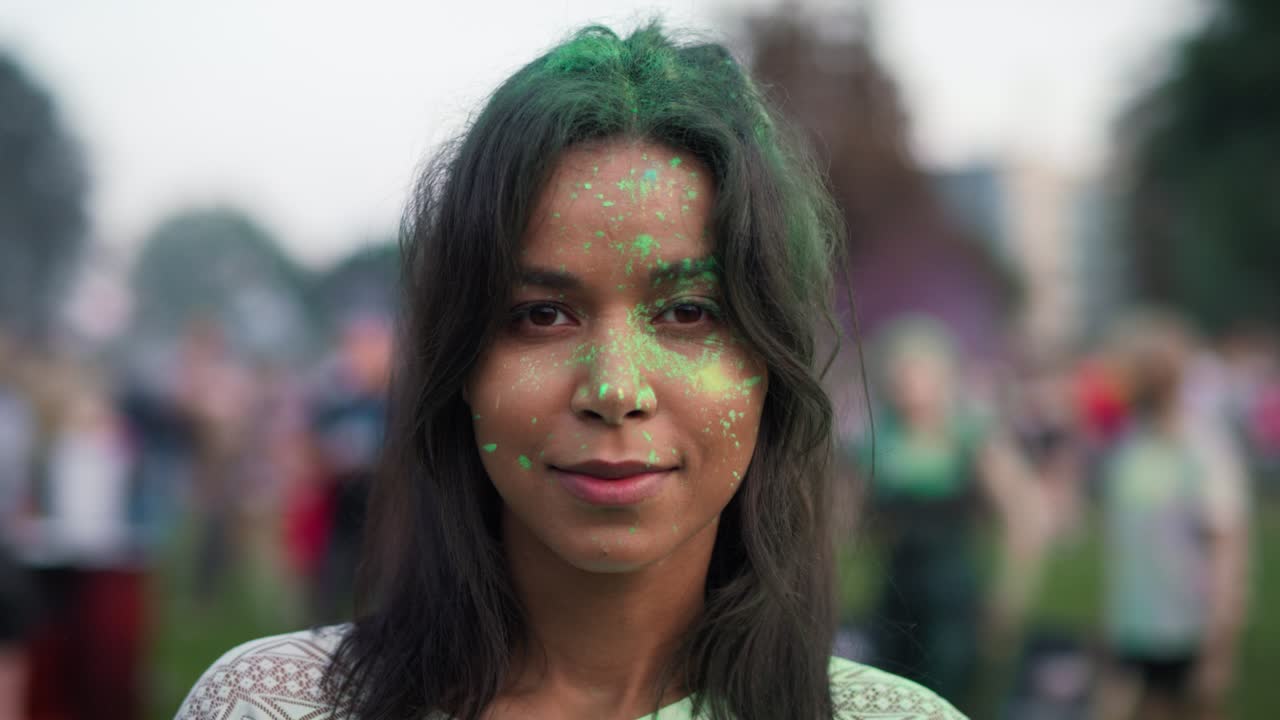 un primer plano de una mujer multirracial mirando a la cámara en el festival de holi. filmado con una cámara de helio rojo en 8k.