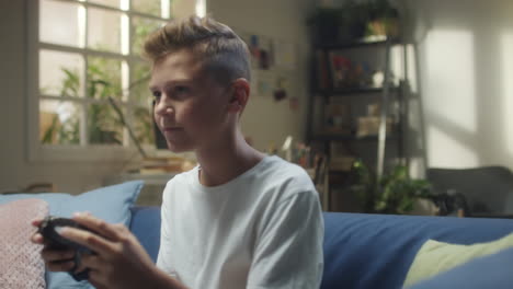 young boy playing video games on a couch