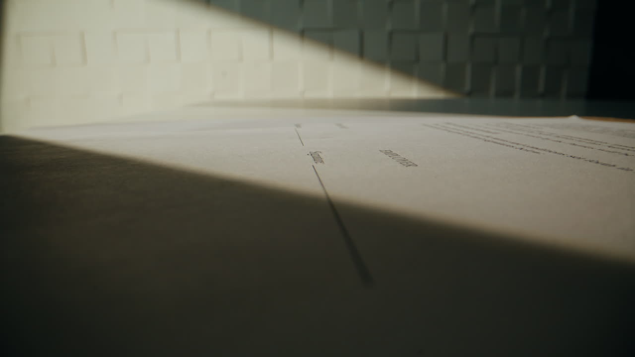 Closeup hands signing agreement at sunbeams desk closeup. Man writing signature