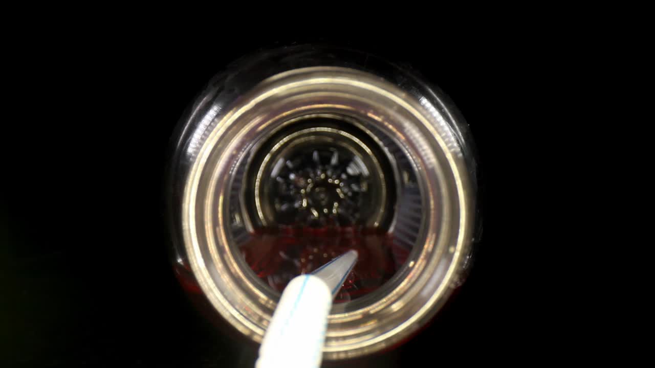 partendo dall'esterno, poi spingendo lentamente nella bottiglia della bevanda sportiva, viaggia fino all'estremità della cannuccia bianca che riposa nel liquido rosso