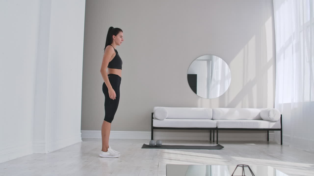 hermosa chica en forma haciendo ejercicio en casa realizando estiramientos laterales en una sala de estar