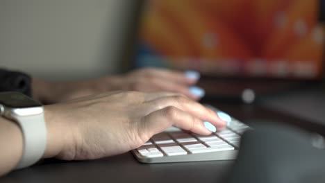 Person-typing-on-white-computer-keyboard,-side-view