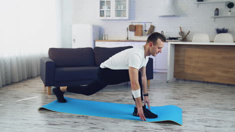 man doing workout at home. young man exercising on a mat on floor during quarantine. fitness at home. healthy lifestyle.