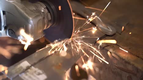 disc cutter slicing a thin steel sheet to get a blade blank while making sparks, close up handheld shot