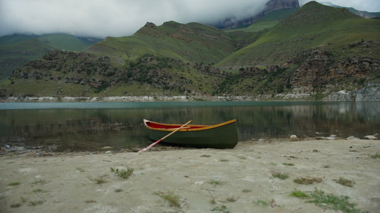 lago de montaña pintoresco con canoa