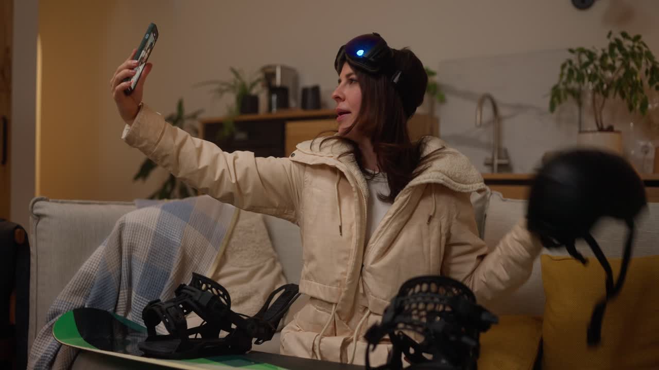 Woman Taking a Selfie Video Call While Relaxing at Home with Snow Gear