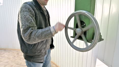 a male researcher rotates the manual wheel of the opening mechanism of the dome doors of a solar observatory. scientific research observation station in the mountains of the caucasus