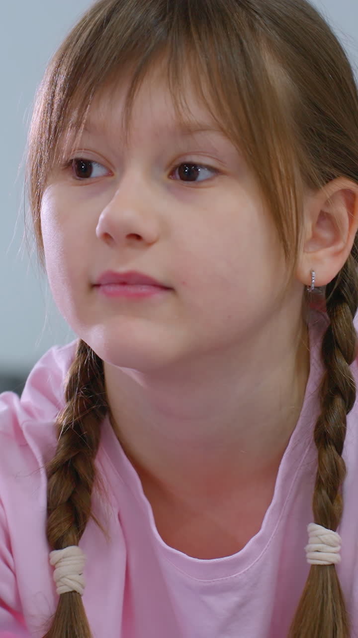 niño pequeño con el cabello atado estirando la mano hacia adelante mientras equilibra el bloque rosa en la espalda, centrándose en la alineación del cuerpo y la postura en la sesión de entrenamiento