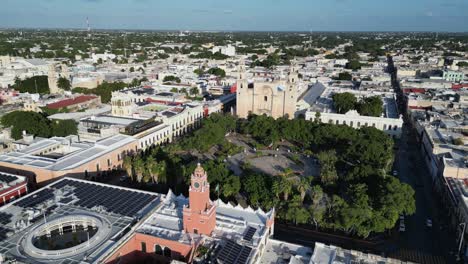 Aerial-pulls-out-from-Plaza-Grande-in-Merida-Mexico,-city-skyline