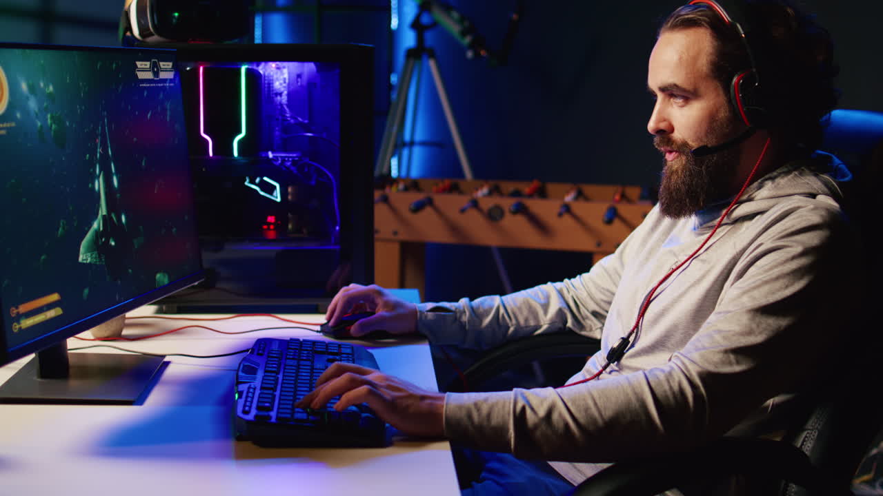 레이저 총알을  ⁇ 는 우주선과 함께 싱글 플레이어 비디오 게임을 하는 네온 조명 아파트에 있는 남자