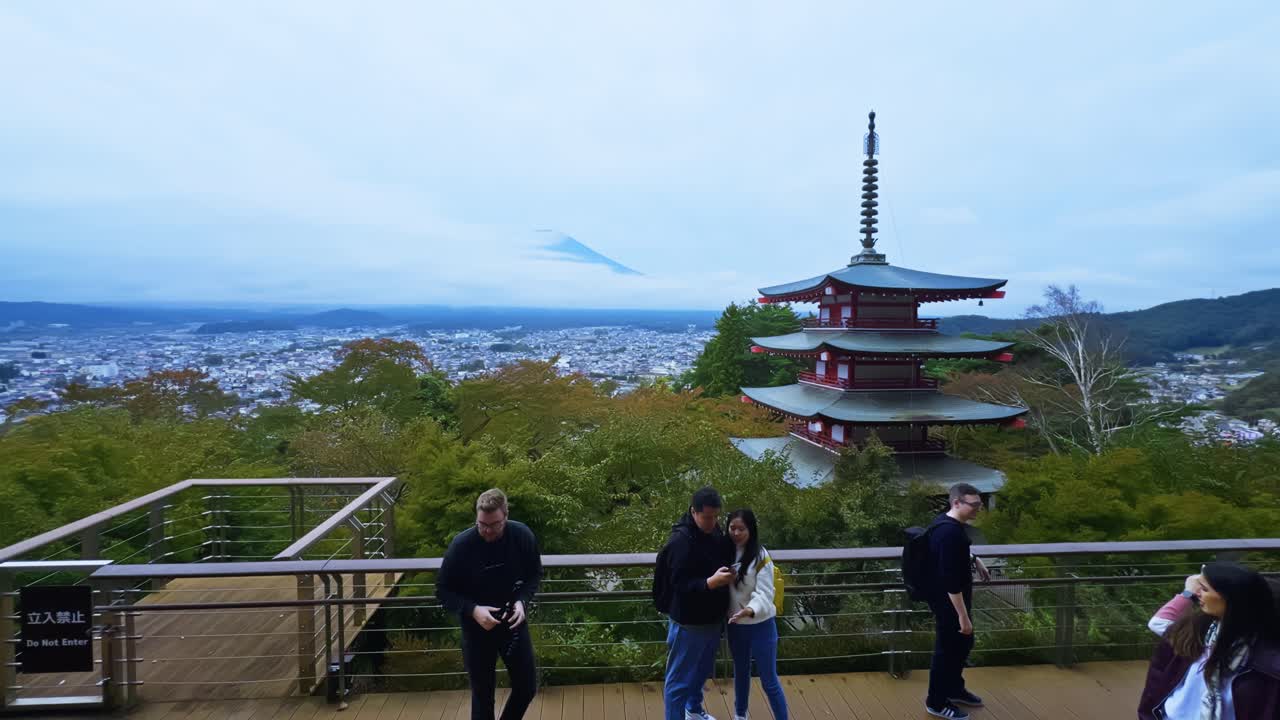 Panning right over tourists at Chureito Pagoda with Mount Fuji backdrop