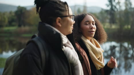 women hug, talking and walking by lake for camping