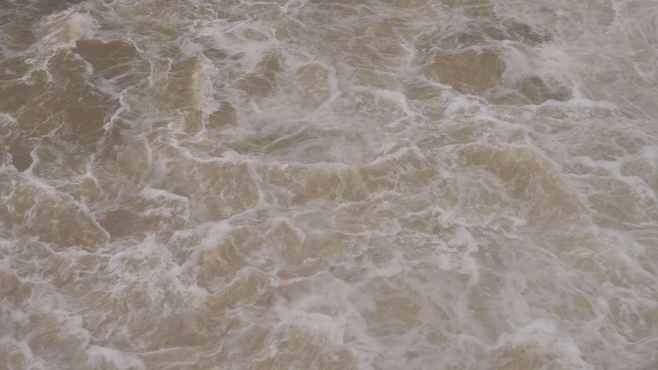 Handheld shot of turbulent water flow from Hinze Dam under heavy rain and water flows during La Ni&ntilde;a, Gold Coast Hinterland, Queensland, Australia