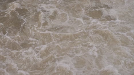 Handheld-shot-of-turbulent-water-flow-from-Hinze-Dam-under-heavy-rain-and-water-flows-during-La-Niña,-Gold-Coast-Hinterland,-Queensland,-Australia