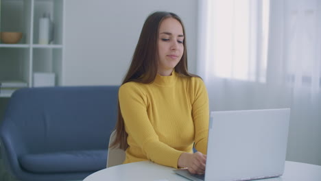 una mujer sentada en la oficina se calienta la espalda. postura y problemas de espalda mientras trabaja en la computadora. calentamiento y ejercicio mientras trabaja en la oficina