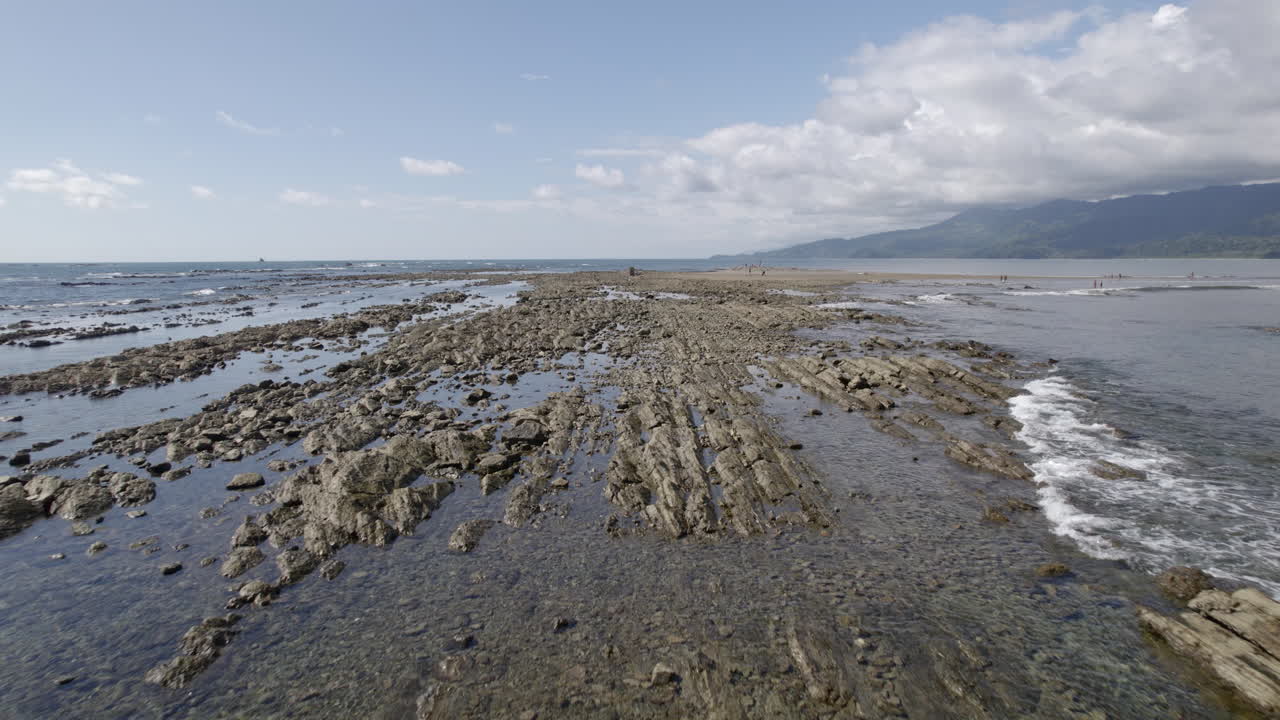 volando bajo sobre rocas formadas en medio del agua de mar, trevallyn, tasmania, australia