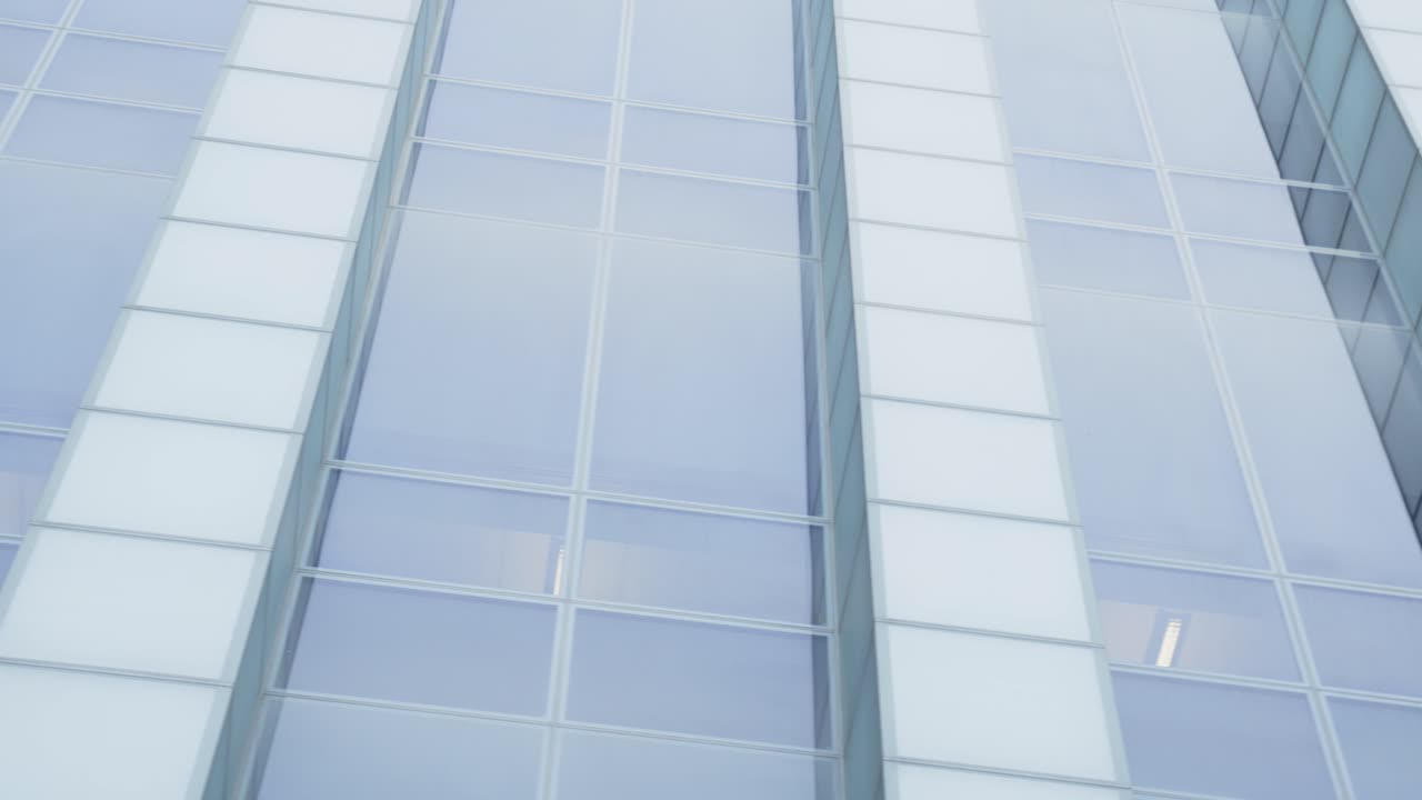 낮은 각도로 패닝하는 도시 기업 본사의 파노라마 외부 샷