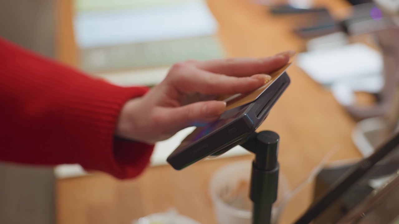 Close-up de Mão Aproximando Cartão de Crédito no Smartphone para Pagamento por Aproximação