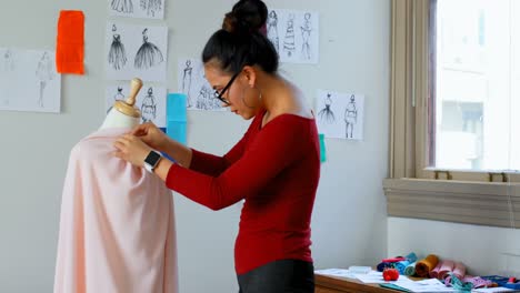 Fashion-designer-working-on-the-dress-makers-model-4k