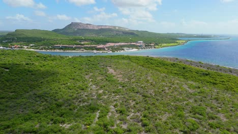 panoramic aerial dolly over dry caribbean landscape to sandals beach resort in the distance