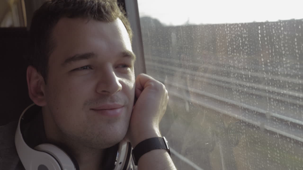 Uomo in viaggio in treno che si gode il panorama esterno