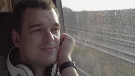 man traveling by train and enjoying outside view