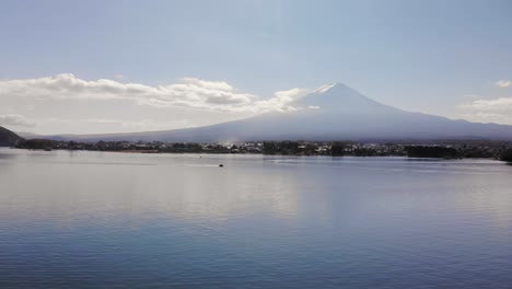 Rising-aerial-over-Lake-with-Mount-Fuji-and-speedboat-on-bright-day