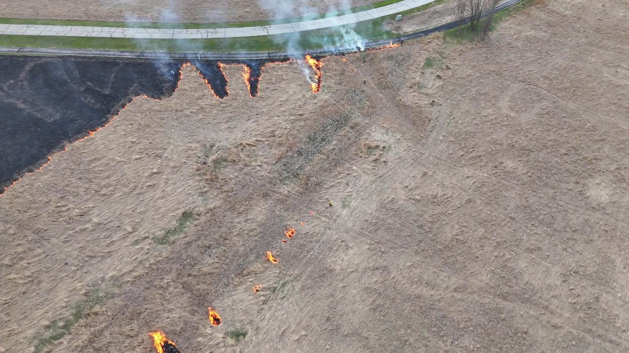 Brave Firefighters quickly light a grass fire to slow the spread of a nearby wildfire. B-roll representative of Carolina fires