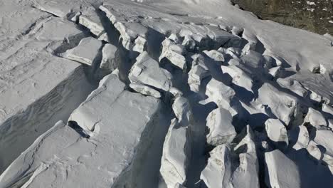 aerial push in: glacier and its multiple crevasses