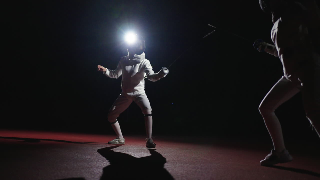 Two fencers competing in a match