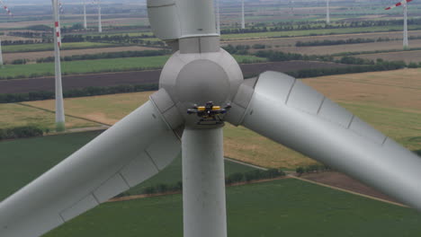imágenes de un dron de servicio de seguridad inspeccionando de cerca una turbina eólica para reparaciones