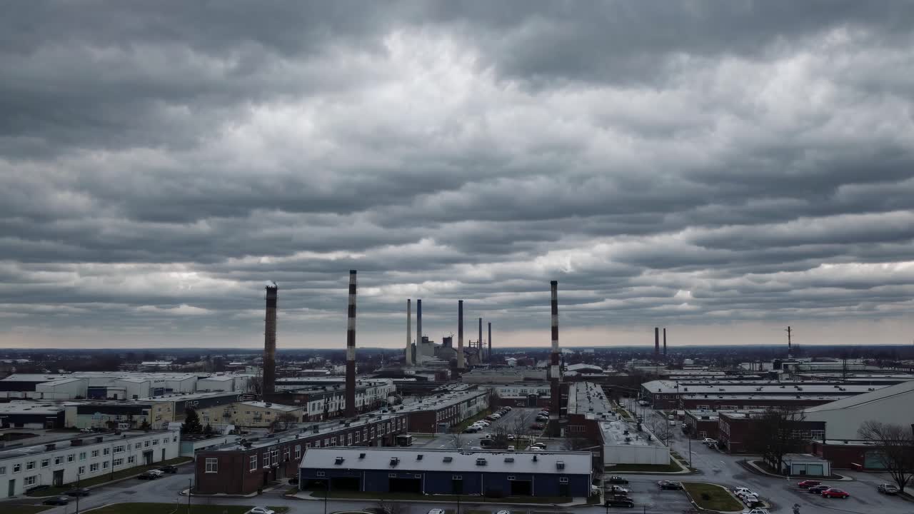 Aerial video of an industrial cityscape under cloudy skies, showcasing a wide-angle view